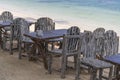 Wooden table and chairs in empty beach cafe next to sea water. Island Koh Phangan, Thailand Royalty Free Stock Photo