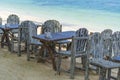 Wooden table and chairs in empty beach cafe next to sea water. Island Koh Phangan, Thailand Royalty Free Stock Photo