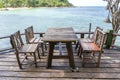 Wooden table and chairs in empty beach cafe next to sea water. Island Koh Phangan, Thailand Royalty Free Stock Photo