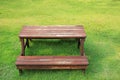 Wooden table and chairs set on green lawn in the garden Royalty Free Stock Photo