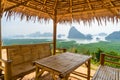 Wooden table and chairs in thai pavilion at Samet Nangshe Viewpoint with sea in Phang Nga Bay, tourist attraction in summer season Royalty Free Stock Photo