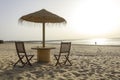 Wooden table and chairs with umbrella on the beach Royalty Free Stock Photo