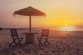 Wooden table and chairs with umbrella on the beach Royalty Free Stock Photo