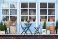 Wooden table and chairs on veranda of house. Exterior street cafe with furnuture. Outdoor home decor. Facade Terrace with wicker b Royalty Free Stock Photo