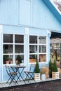 Wooden table and chairs on veranda of house. Exterior street cafe with furnuture. Outdoor home decor. Facade Terrace with wicker b Royalty Free Stock Photo