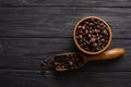 Wooden table with coffee beans in scoop composition. Vintage wood background texture and old spoons with grains top view Royalty Free Stock Photo