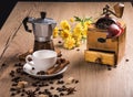 On wooden table is a coffee maker mocha, vintage coffee grinder. White saucer with a cup are cinnamon sticks. Coffee Royalty Free Stock Photo