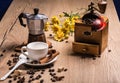 On wooden table is a coffee maker mocha, vintage coffee grinder, white saucer with a cup are cinnamon sticks. Coffee Royalty Free Stock Photo