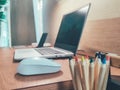 At wooden table with computer monitor in grey spacious home office interior. Concept of young people work from home WFH.No focus Royalty Free Stock Photo