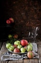 On a wooden table on a cotton towel a metal dish with fresh red and green apples Royalty Free Stock Photo