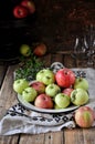 On a wooden table on a cotton towel a metal dish with fresh red and green apples Royalty Free Stock Photo