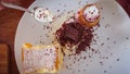 On the wooden table: custard cake, ice cream in a waffle cone, ice cream sprinkled with chocolate chips