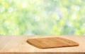 Wooden table with cutting Board on blurred spring background wit