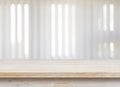 Wooden table on defocuced window with jalousie background