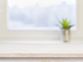 Wooden table on defocuced winter window background