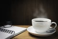 Wooden table desk with coffee. Workspace with note book, pen and coffee cup on wooden background with copy space Royalty Free Stock Photo