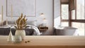 Wooden table, desk or shelf close up with ceramic and glass vases with dry plants, straws over blurred view of japandi bedroom Royalty Free Stock Photo