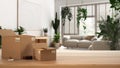 Wooden table, desk or shelf with stack of cardboard boxes over blurred view of minimal living room, houseplants interior design, Royalty Free Stock Photo