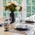 Wooden table in dining room with elegant table setting Royalty Free Stock Photo