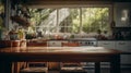 Wooden table in the foreground with a blurred background of a kitchen with a large window through which you can see a grove of Royalty Free Stock Photo
