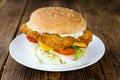 Wooden table with a fresh made Fish Burger Royalty Free Stock Photo