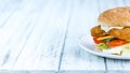 Wooden table with a fresh made Fish Burger Royalty Free Stock Photo