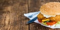 Wooden table with a fresh made Fish Burger Royalty Free Stock Photo