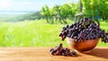 Wooden table with fresh red grapes and free space on nature blurred background, vineyard field. Generated AI. Royalty Free Stock Photo
