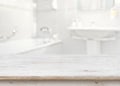 Wooden table in front of blurred bathroom interior as background Royalty Free Stock Photo