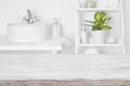 Wooden table in front of blurred white bathroom shelves background Royalty Free Stock Photo