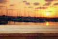 wooden table in front of blurred yachts in pier at sunset