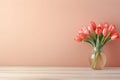 Wooden table with glass vase with bouquet of tulips flowers near empty, blank coral wall. Home interior background Royalty Free Stock Photo