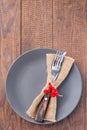 Wooden table with gray plate and fork and knife with autumn decoration, vertical, top view, copy space Royalty Free Stock Photo