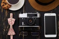 Wooden table with hat, old-fashioned camera, eyeglasses, floral