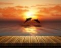 Wooden table looking out to sea with dolphins jumping Royalty Free Stock Photo