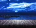 Wooden table looking out to sea at night Royalty Free Stock Photo