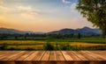 Wooden table, mountain horizon, and sunset field blur serene