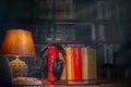 On a wooden table next to the lamp are headphones, a phone, a stack of books and glasses. The concept of modern technology and Royalty Free Stock Photo