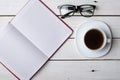 Wooden table with notebook glasses and a cup of coffee, top view