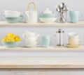 Wooden table over background of shelves with kitchenware Royalty Free Stock Photo