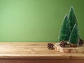 Wooden table with pine tree decoration over green background. Christmas and winter holidays mock up for design and product Royalty Free Stock Photo