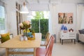 Wooden table and pink chair in dinning room at home. Colorful interior of dinning room.