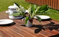 A wooden table with plates prepared for a family breakfast otdoors