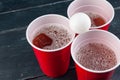 Wooden table with red cups and ball for beer pong Royalty Free Stock Photo