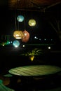 wooden table with seats placed in garden lights and wooden roof with tree and lights in background