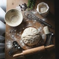 A wooden table set for baking includes a ball of dough dusted with flour on a round Royalty Free Stock Photo