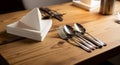 A wooden table set for dining, featuring neatly arranged silver utensils including forks Royalty Free Stock Photo