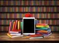 Wooden table with a stack of colored books, tablet, pencil, school supplies, apple. Education concept, back to school. Blurred Royalty Free Stock Photo