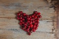 on a wooden table there is a heart symbol made of cherries