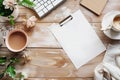 On the wooden table there is a white tablet for notes, a cup of coffee and a flower. Relaxed and comfortable atmosphere Royalty Free Stock Photo